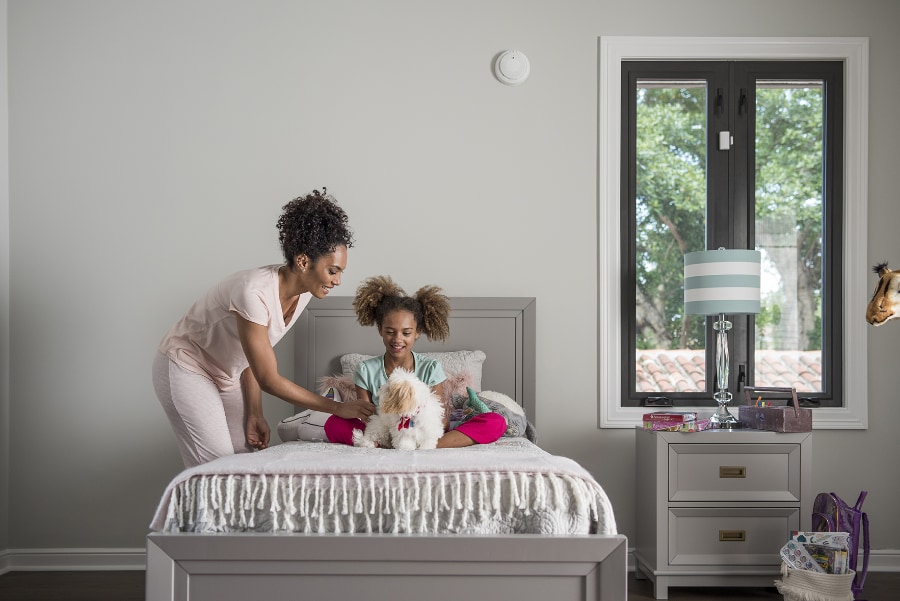 mother and daughter at bedtime with smoke sensor